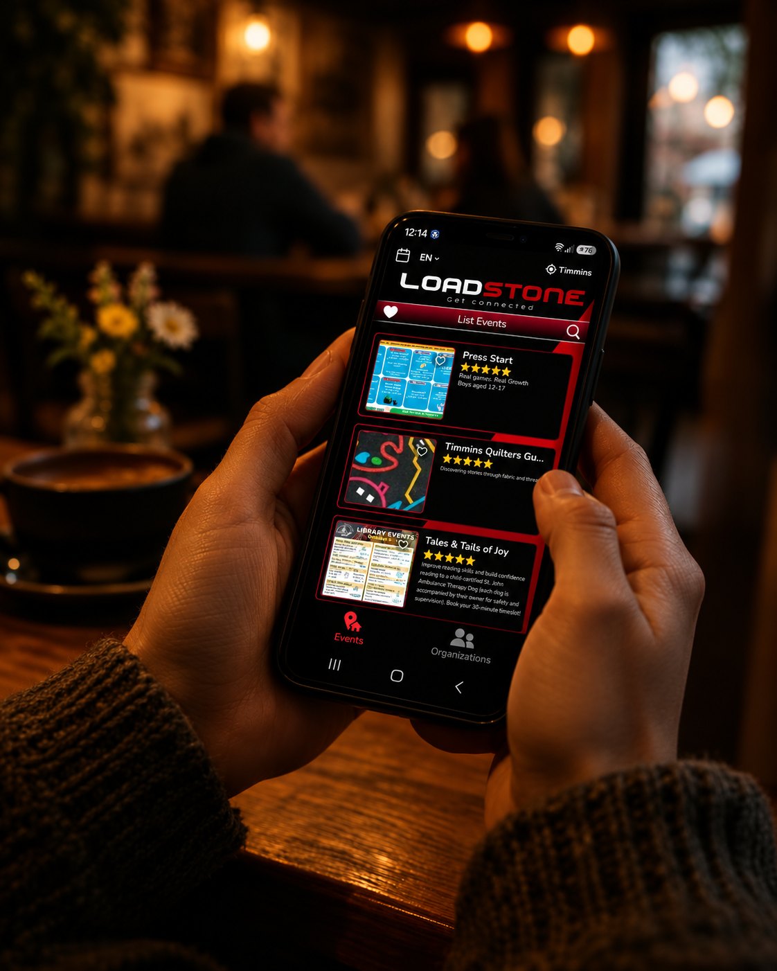 Hands holding a phone showing the Loadstone events feed for Timmins